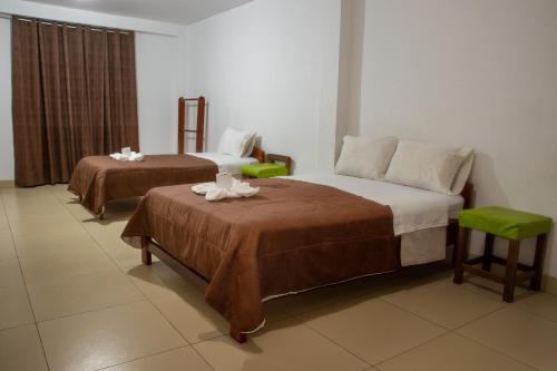 查查波亚斯Hostal La Morada的酒店客房,设有两张床和两张桌子