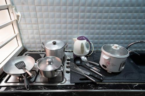 塔那那利佛Aparthotel Madeleine的厨房炉灶,上面有锅碗瓢盆