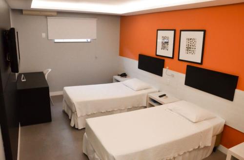 费拉迪圣安娜圣多明戈斯酒店的一间设有两张床和橙色墙壁的客房