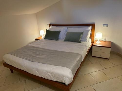 米兰马瑞提那Appartamento Perla Marina的一间卧室配有一张带2个床头柜的大床