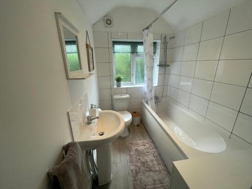 麦克尔斯菲尔德Tucked away house in Macclesfield的一间带水槽、浴缸和卫生间的浴室