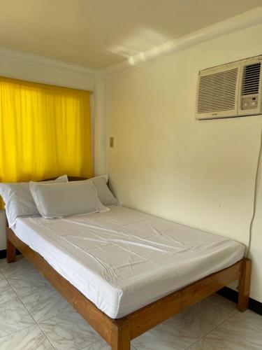 马斯巴特Maria Kulafu Studio Apartment Kinamaligan- Beside Eglin Gas FREE Wifi的配有空调的房间的一张床位