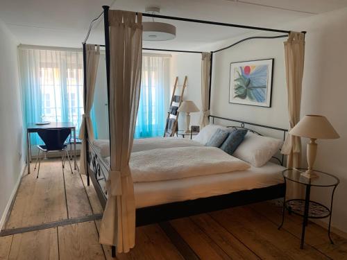 图恩Chez Muna & Lucien的一间卧室配有一张天蓬床和一张书桌