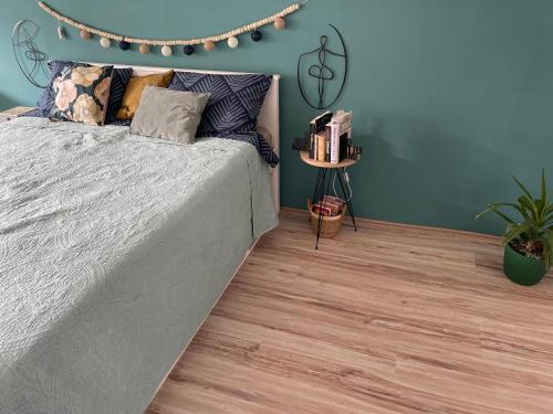 彼得罗瓦拉丁Azul Apartman的一间卧室配有一张床,铺有木地板