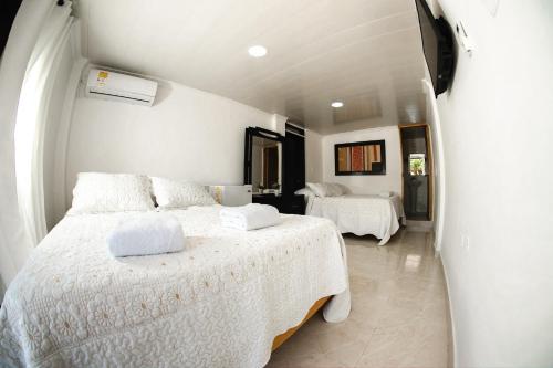 圣安德烈斯Hotel Campestre Dorado SAI的一间卧室配有两张带白色床单的床