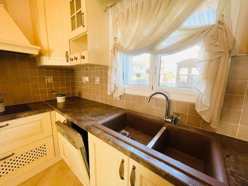 尼亚·卡利克拉提亚D & J Luxury House的厨房设有水槽和窗户。