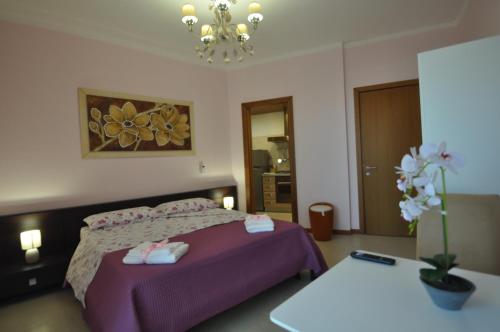 马蒂诺Boat dreams , garden relax的一间卧室配有一张带紫色床单的床和一张桌子