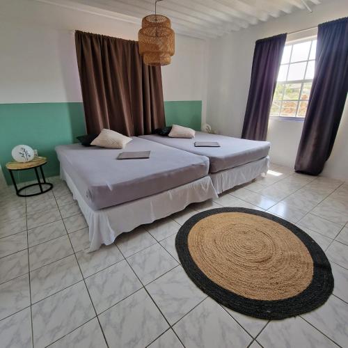 WestpuntNos Soño Stay and Dive的卧室配有两张床,地板上铺有地毯。