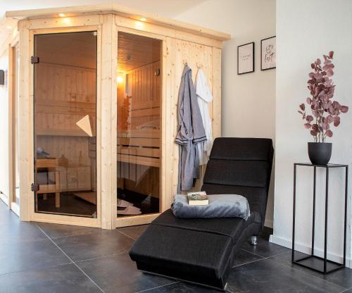 EltenNOVO MESTO - Exklusive Wellnesswohnung am Eltenberg mit Sauna & Gym的客房设有带一对椅子的木制衣柜。