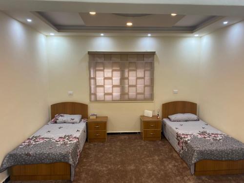 杰拉什Musab apartment的客房设有两张床和窗户。