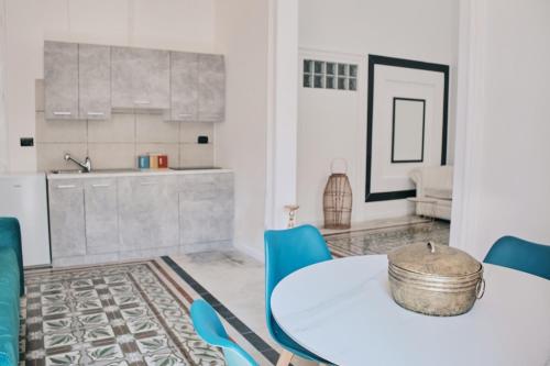 布林迪西Appartamenti Luxury Greco的一间配备有白色桌子和蓝色椅子的用餐室