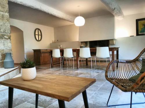 卢马罕Mas provençal, parc de 6000m2, Lourmarin à pied的客厅配有桌子和白色椅子