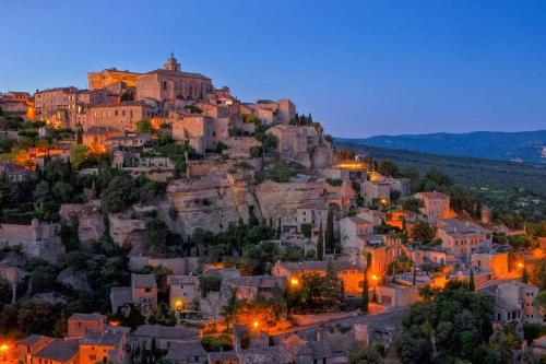 阿普特Appartement+Terrasse en Provence dans le Luberon的夜晚可欣赏到山上的小镇景色