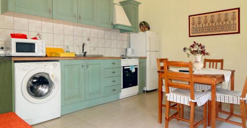 里瓦的亚ANEMOESSA APTS的厨房配有洗衣机和桌椅
