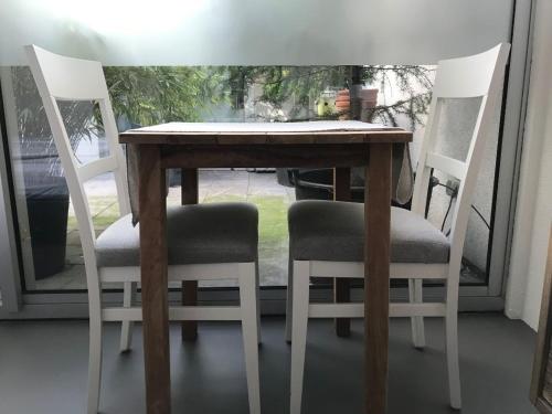 阿姆斯特丹雅堡别墅旅馆的一张带两把椅子的木桌和一张带窗户的桌子