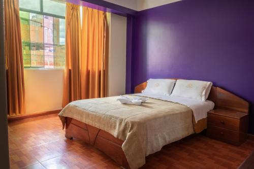 查查波亚斯Hotel California的一间卧室配有一张紫色墙壁和窗户的床