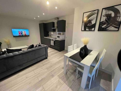 克罗伊登Stylish and Cosy 2 bedroom flat in Croydon的客厅配有黑色沙发和桌子