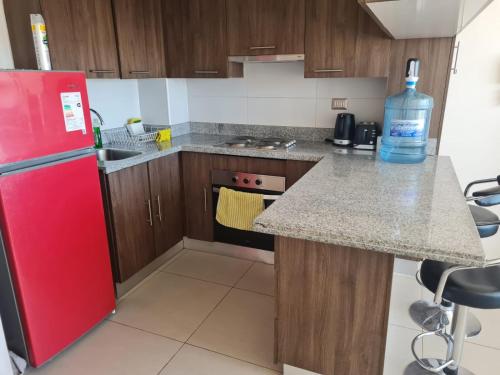 卡拉马Agradable departamento central的厨房配有红色冰箱和台面