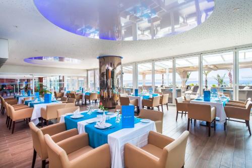 阿加迪尔Amadil Ocean Club的餐厅设有蓝色的桌椅和窗户。