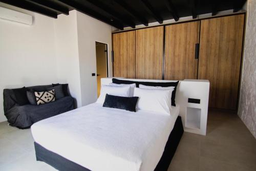 卡拉法蒂斯Blue Eye Grand Villa Mykonos的卧室配有一张白色的大床和一张沙发。