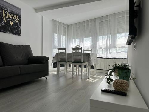 卡马乔Apartamento Temático Cantabria的客厅配有桌椅和沙发