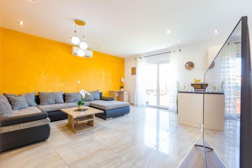扎达尔KM Exclusive Apartments的带沙发和黄色墙壁的客厅