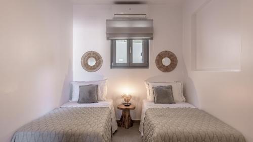 阿达玛斯Esperanza Apartments的白色墙壁客房中的两张单人床