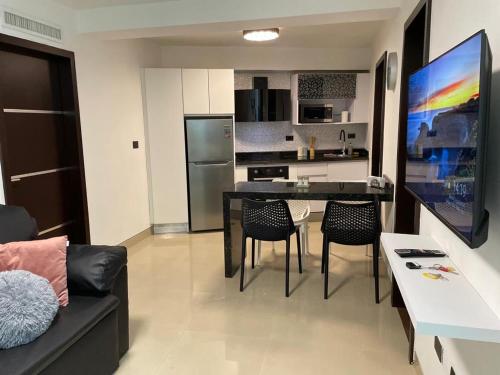 波拉马尔Elegante apartamento en Playa el Angel的厨房以及带黑色桌椅的起居室。