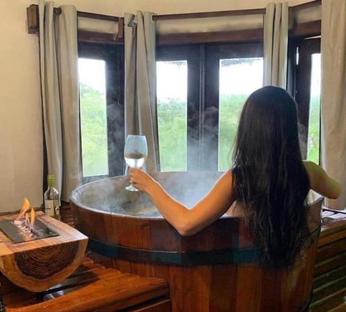 坎巴拉Rodeio das Lagoas的浴缸里拿着一杯葡萄酒的女人