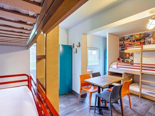 巴黎巴黎沙蒂永门F1酒店的小房间设有桌椅和一张双层床