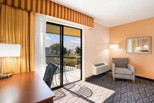 韦纳奇SureStay Hotel by Best Western Wenatchee的酒店客房设有桌椅和阳台。
