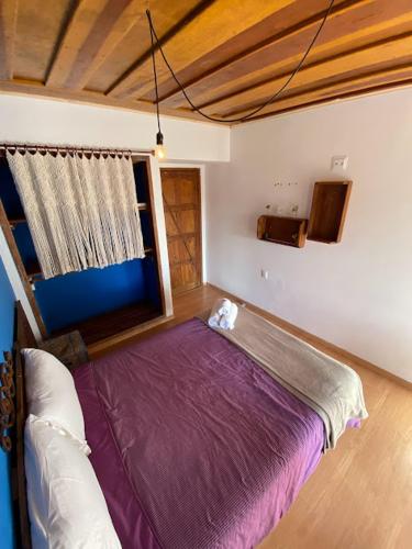 拉夫拉斯诺瓦斯Solar Maria Gomes - Lavras Novas MG的一间卧室,在房间内配有一张大紫色床