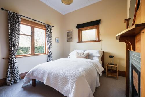 但尼丁Cottage on Aotea的一间卧室设有一张床和一个窗口