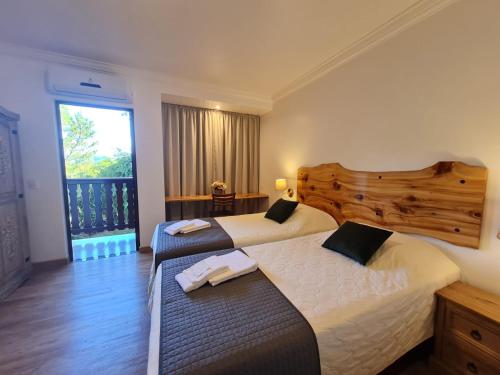 特雷齐蒂利亚斯施耐德酒店的配有窗户的酒店客房内的两张床
