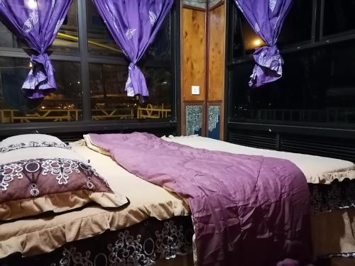 宜力Royal Belum Mystical的紫色窗帘间的一张床