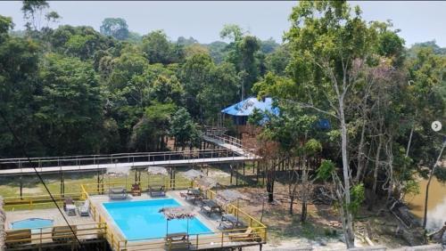伊基托斯Ceiba Amazon Lodge的一个带游泳池和树木的度假胜地