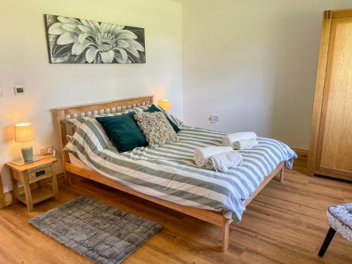 霍尔斯特德Aylesbury Lodge的一间卧室配有一张大床和毛巾