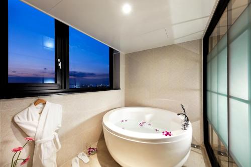 平泽市Pyeongtaek K-tree Hotel的带浴缸的浴室和窗户。