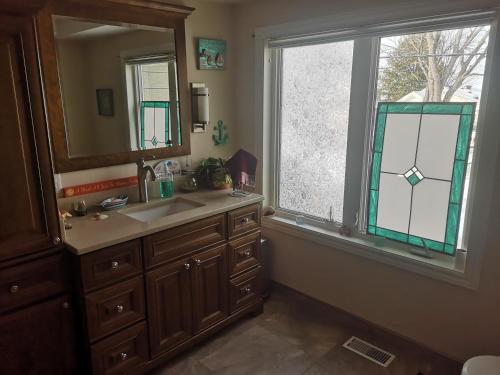 北湾Paradise Inn的一间带水槽和镜子的浴室以及窗户。