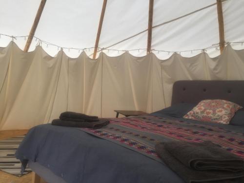 HeydonInfinite Skies Tipi's的帐篷内一间卧室,配有一张床