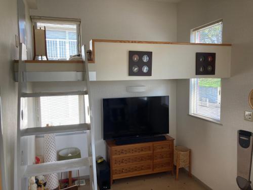 钏路art.paradigm的客厅配有双层床和电视。