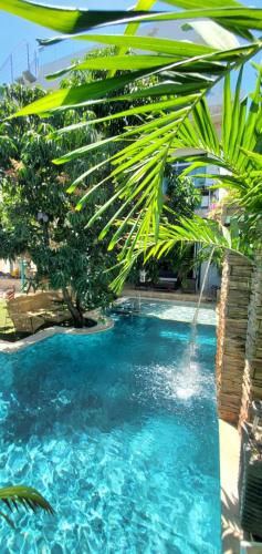 圣玛尔塔Ritacuba House Boutique的一片蓝水和棕榈树的游泳池