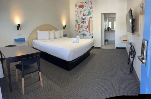 皮斯莫比奇大洋棕榈汽车旅馆的酒店客房配有一张床铺、一张桌子和一张书桌。