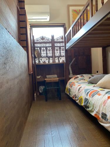 守口Casa del girasolカサデルヒラソル的一间卧室配有一张床和一个楼梯间