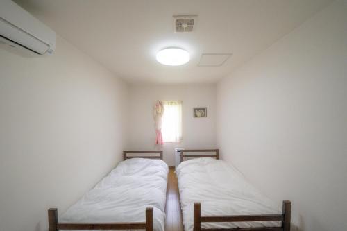 小樽小樽民泊太田1号館的小型客房 - 带2张床和窗户