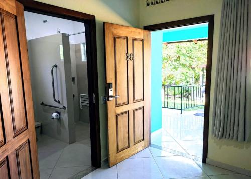 戈亚斯州上帕莱索Pousada Casa Rosa的通往带淋浴的浴室的开放式门