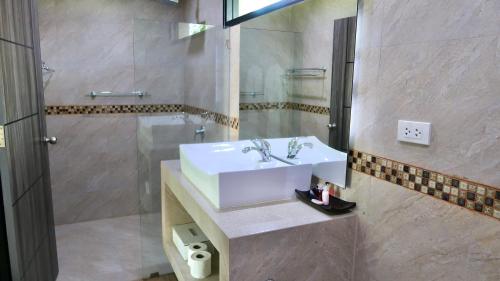 拉威海滩Jasmine Village的浴室配有白色水槽和淋浴。