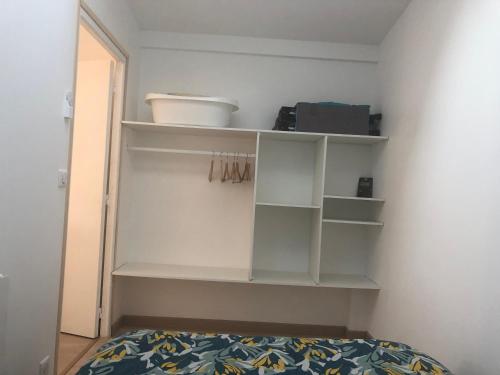 布隆Appartement paisible proche centre ville的卧室配有白色的架子和床