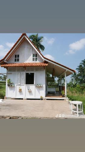 外南梦Pondok isoke的前面有长凳的白色房子