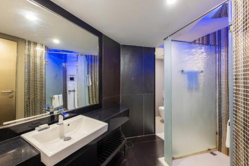 芭堤雅市中心圣塔拉芭堤雅酒店的一间带水槽和玻璃淋浴的浴室